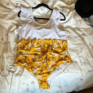 Bathing Suit with white top and yellow flowers on bottom with tie around waist.